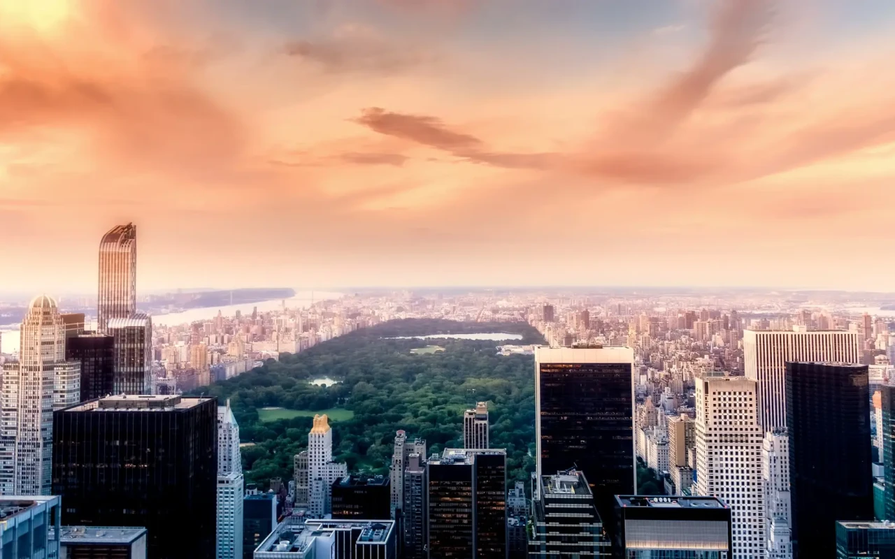 Scenic view of Central Park with lush greenery, walking paths, and city skyline in the background