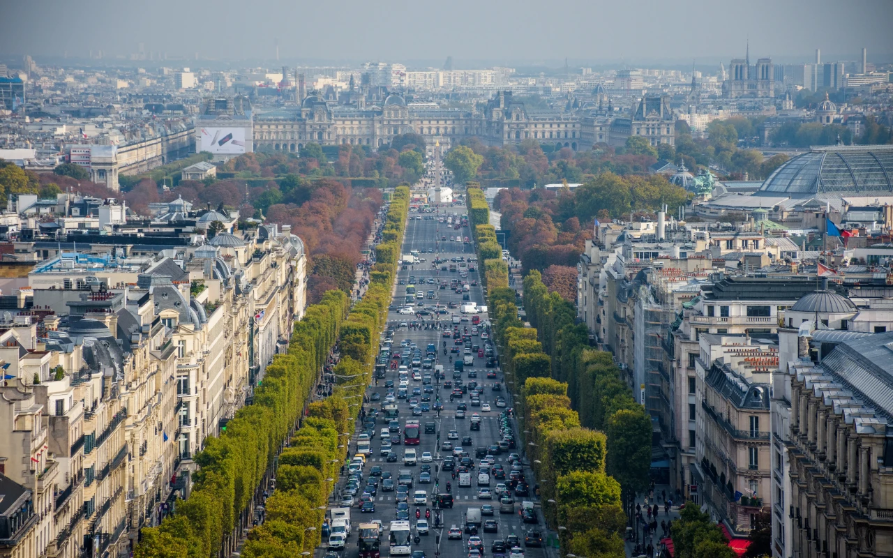 People strolling on the Champs Elysees, Paris, with the iconic Arc de Triomphe in the background