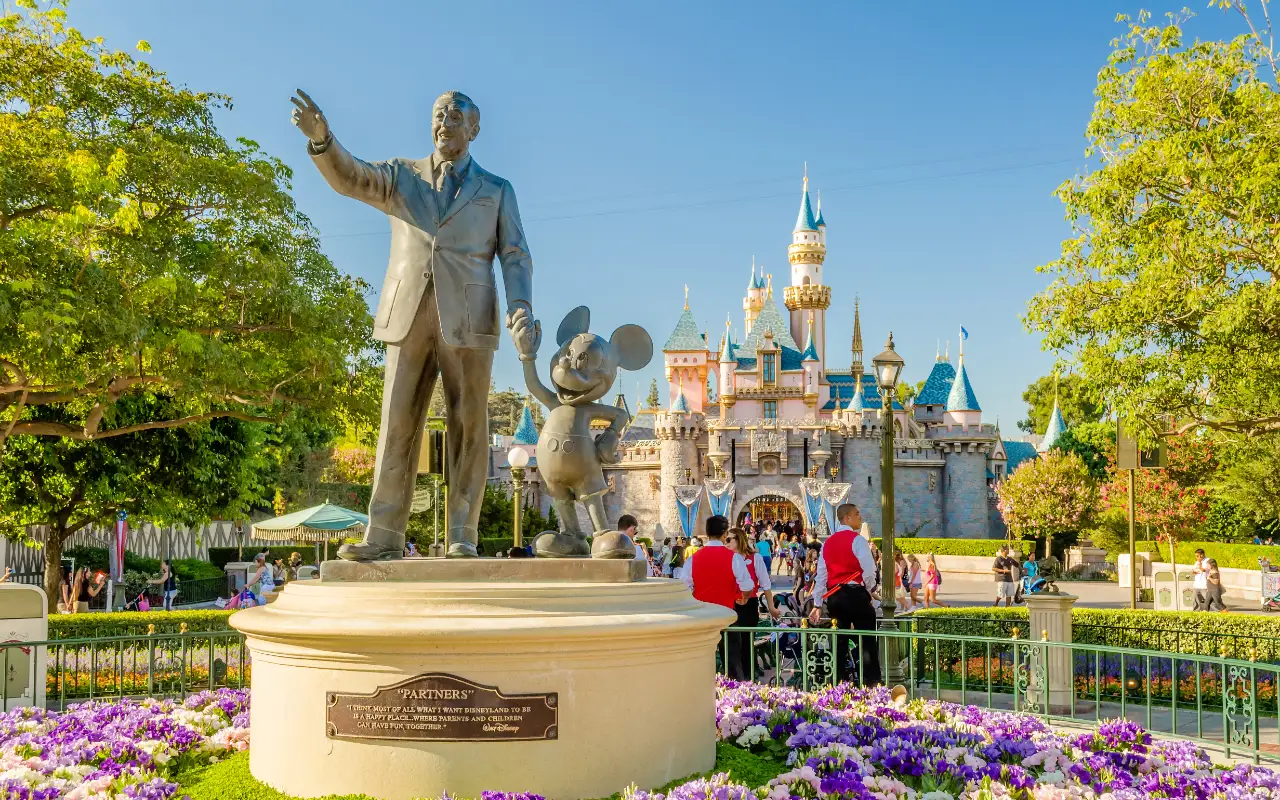 Group of happy kids and families enjoying a fun-filled day at Disneyland Park with iconic rides and attractions in the background