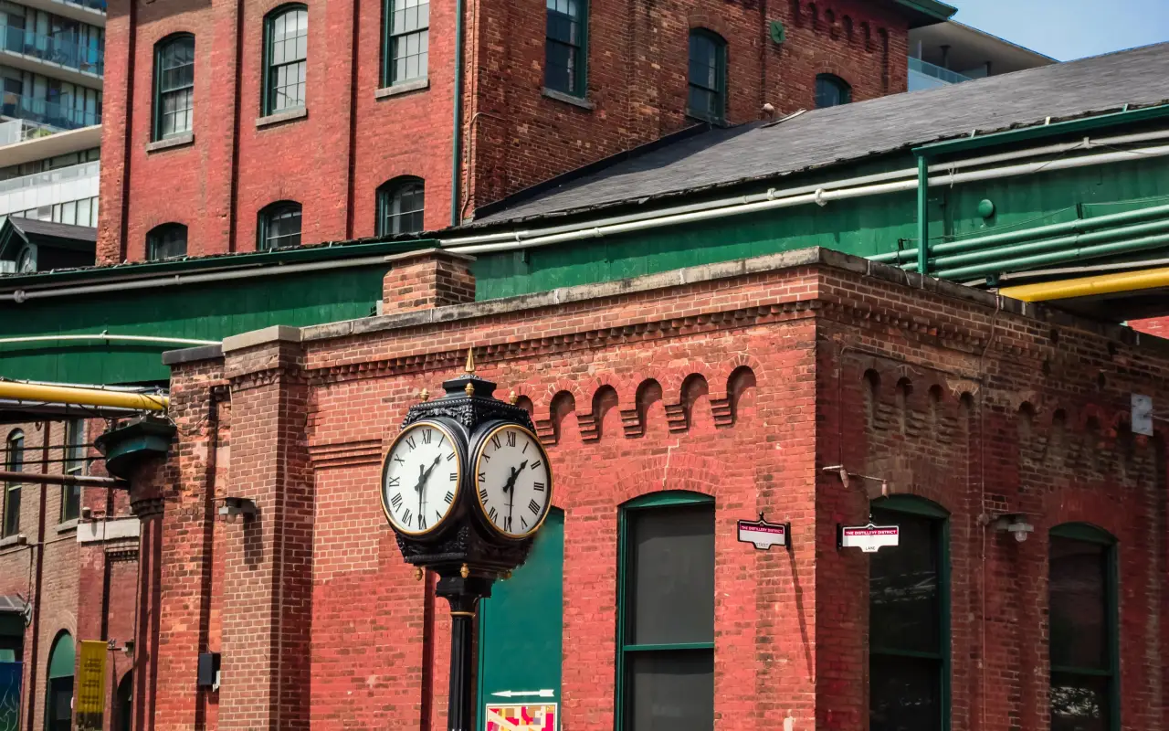 Historic red brick building with a clock in the foreground