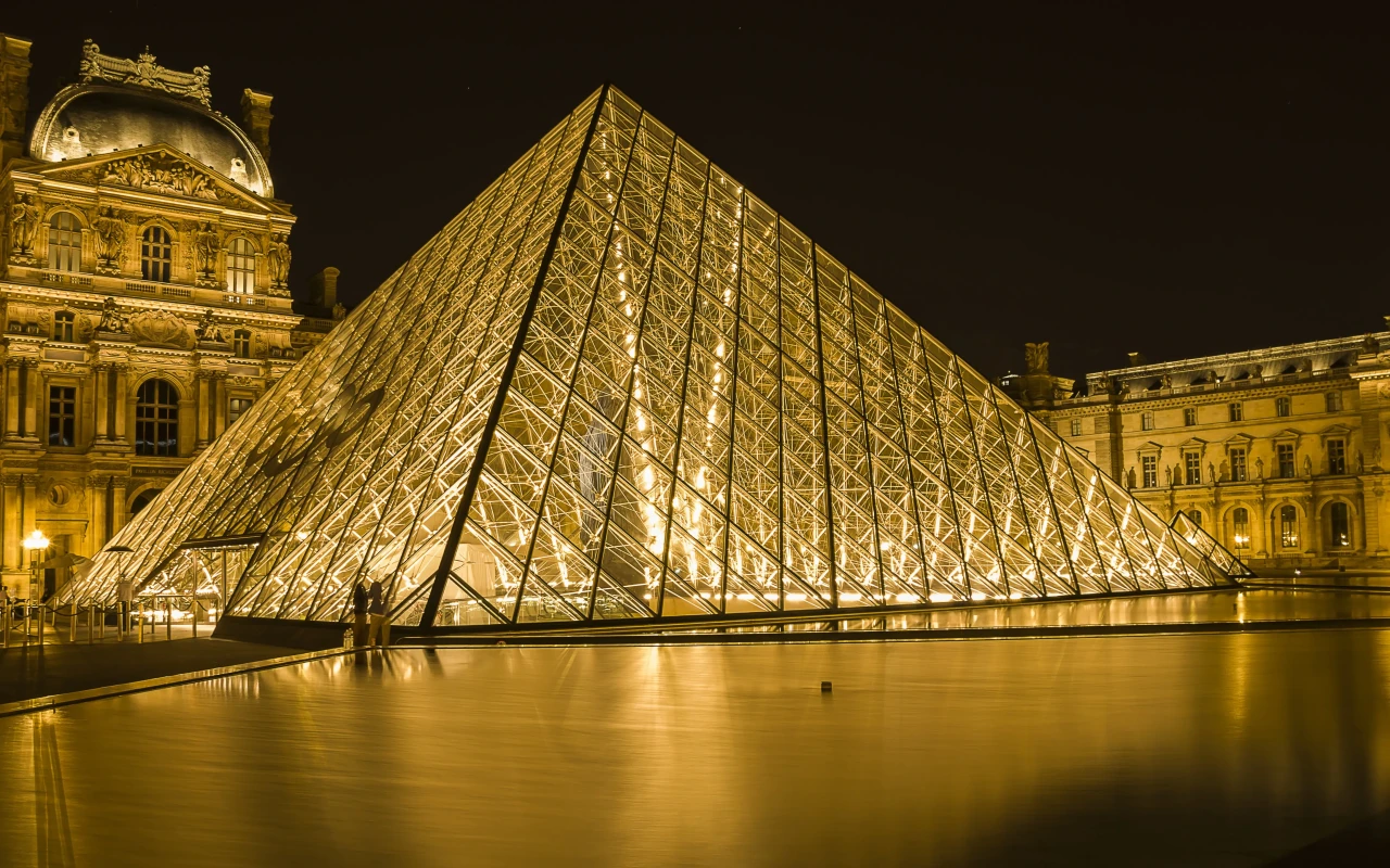 Louvre Museum exterior, showcasing the iconic glass pyramid and historic architecture
