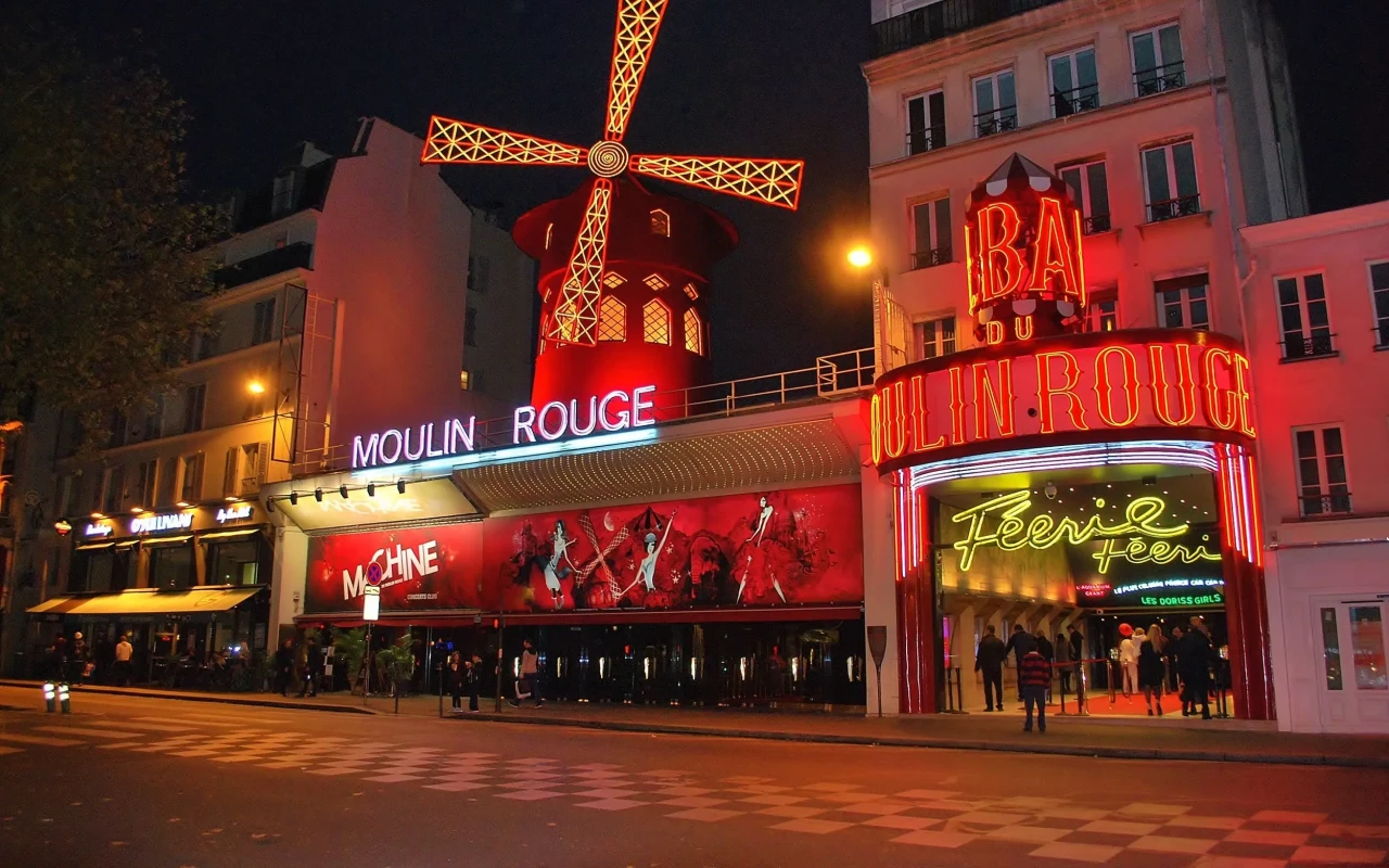 A vibrant image of Moulin Rouge, the iconic Parisian cabaret, with its red windmill and lively atmosphere