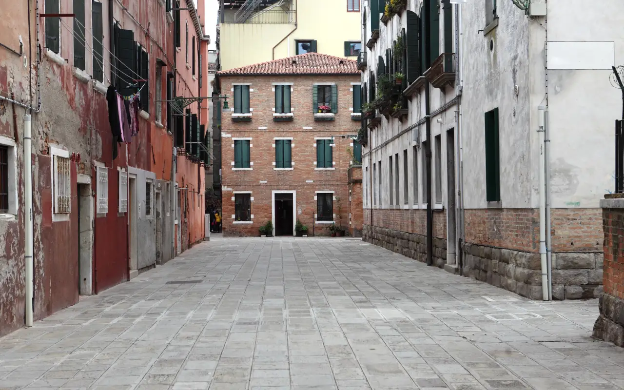 A quiet alleyway in Venice with colorful buildings