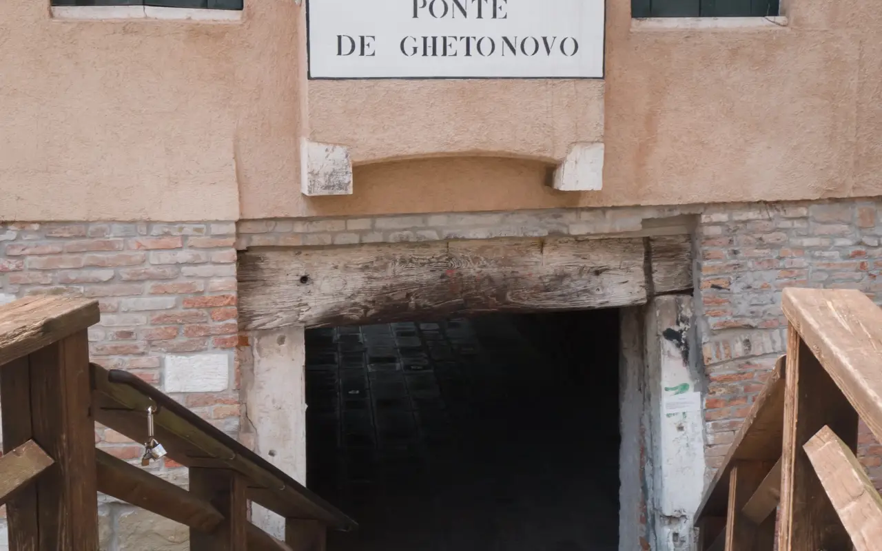Entrance to the Ghetto Novo in Venice with wooden stairs and a sign