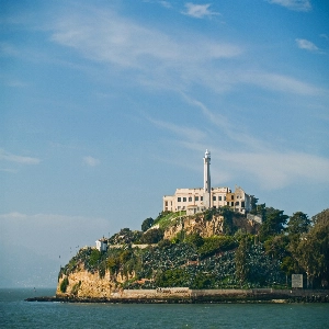 Scenic view of the historic Alcatraz Island with surrounding waters and cloudy sky