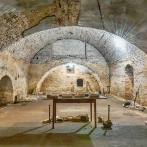 Underground tunnels of the ancient Catacombs of Rome, featuring labyrinthine passageways and tombs