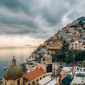 Couple enjoying a romantic sunset dinner overlooking the beautiful Amalfi Coast in Italy