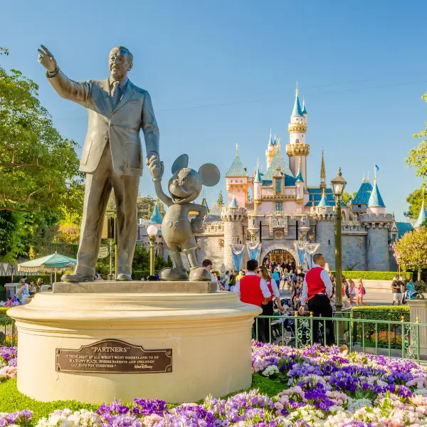 Group of happy kids and families enjoying a fun-filled day at Disneyland Park with iconic rides and attractions in the background